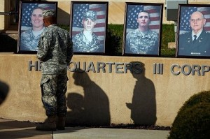A US Army soldier looks at the photographs of those killed at Fort Hood